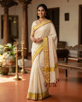 Kerala Cotton Saree - Model wearing off-white cotton saree with gold and maroon border and tassel detail
