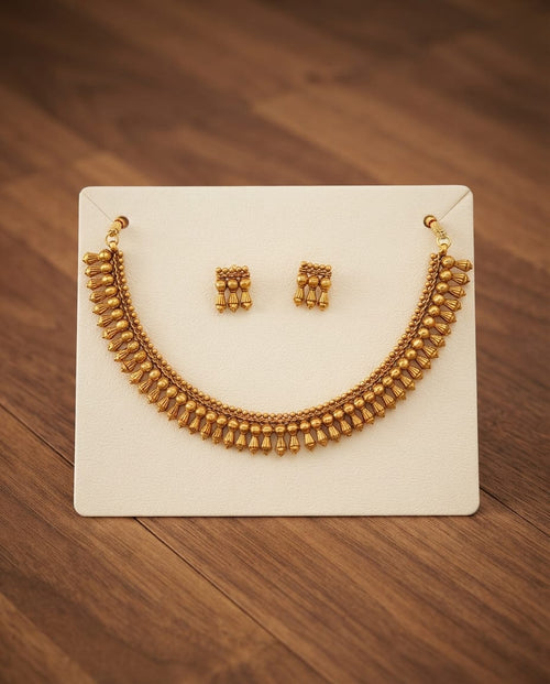Antique gold necklace and earring set on display