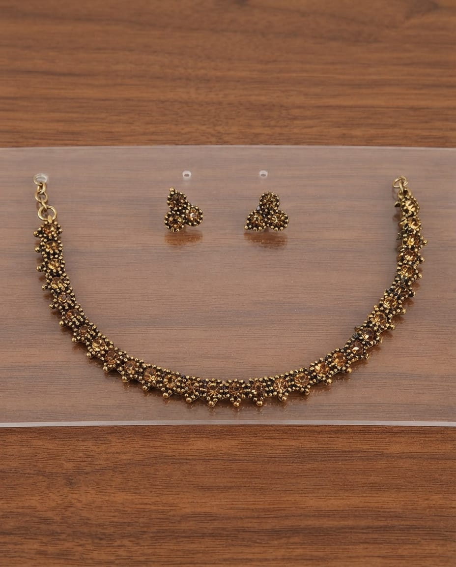 Floral antique gold necklace and earring set on display board
