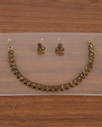 Floral antique gold necklace and earring set on display board
