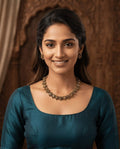 Floral antique necklace and earring set worn by model in teal kurta