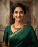 Model wearing antique gold necklace and earrings with green saree